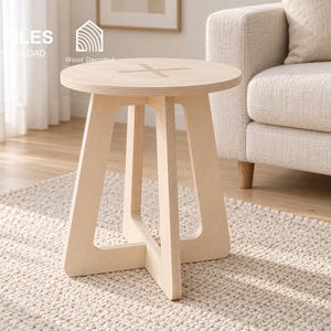 May include: A light-colored wooden side table with a circular top featuring a cross-shaped inlay and a base composed of four interlocking legs. The table has a smooth, natural wood grain finish and a sturdy, open-frame construction.