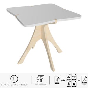 May include: A white, square table with rounded edges and a unique, four-legged base made of wood. The table is designed for CNC milling and comes with digital files in various formats, including ZIP, DXF, SVG, STP, and PDF.