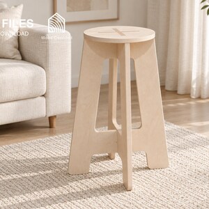 May include: A light-colored wooden stool featuring a circular seat with a cross-shaped cutout and four interlocking legs. The image includes text reading CNC FILES, DIGITAL DOWNLOAD, and Wood Decoded, along with icons for DXF, SVG, STP, and IGS file formats.