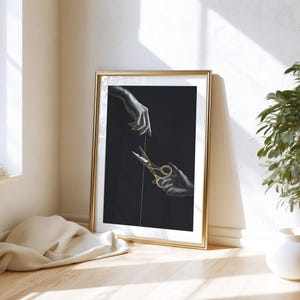 May include: A framed art print featuring a black background with two detailed monochromatic hands. One hand reaches down from the top, while the other hand holds a pair of gold-coloured scissors, cutting a thin vertical line that runs through the centre.