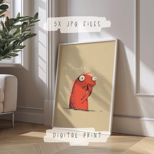 May include: A framed digital print featuring a red, cartoonish monster with large eyes and a worried expression. The text "It stinks" is above the monster. The words "5X JPG FILES" and "DIGITAL PRINT" are also visible.