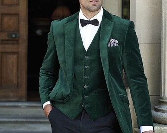 May include: A dark green velvet suit with a matching vest and black bow tie. The suit jacket has a single button closure and a pocket square.