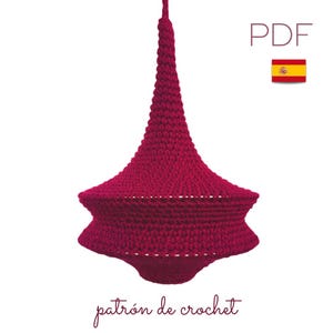 Könnte beinhalten: Ein Häkelmuster für einen roten, hängenden Lampenschirm in Form eines Kegels. Das Muster ist als PDF-Download verfügbar. Der Text "patrón de crochet" steht unter dem Bild.