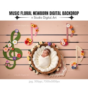 以下が含まれることがあります： 新生児が、花柄のアクセントと音符に囲まれた籐のバスケットの中で眠っています。背景は薄いピンク色で、五線譜のような黒い線が引かれています。