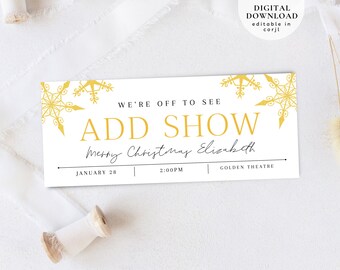 May include: A white ticket with gold snowflake designs. The text reads "We're off to see ADD SHOW Merry Christmas Elizabeth" with the date "January 28", time "2:00PM", and location "Golden Theatre".