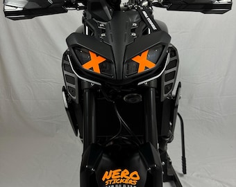 May include: Black motorcycle with orange 'X' stickers on the headlights and a 'NERO STICKERS YAMAHA' sticker on the front fender.