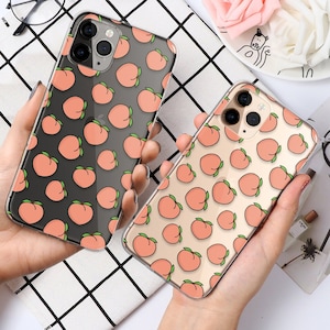 May include: Two clear phone cases with peach designs. The cases are made of a clear plastic material and have a peach pattern on them. The cases are designed to fit a smartphone.