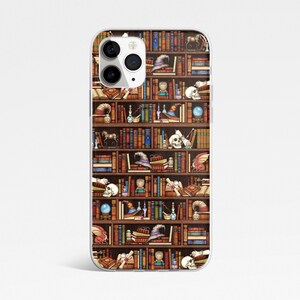 May include: A clear phone case with a design of a bookshelf filled with books, skulls, potions, and other magical items. The bookshelf is brown with gold accents.