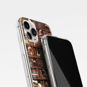 May include: A clear phone case with a design of a bookshelf filled with books, a skull, a hat, and other objects. The case is shown on top of a black phone.