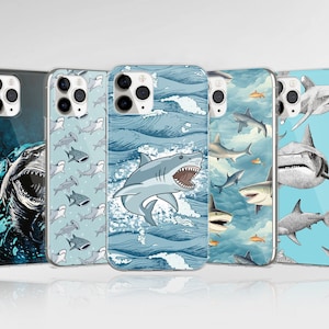 Può includere: Set di quattro custodie per telefono con diversi design di squali. Le custodie sono tutte trasparenti con uno sfondo blu e bianco. Una custodia presenta uno squalo grande con un motivo blu e bianco, un'altra custodia presenta uno squalo piccolo con un motivo bianco e blu, un'altra custodia presenta uno squalo con un motivo bianco e blu e l'ultima custodia presenta uno squalo con un motivo bianco e blu.