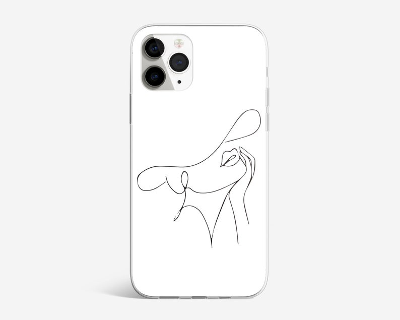 May include: A white phone case with a black line drawing of a woman's face with a hat on. The woman is looking up and to the right.