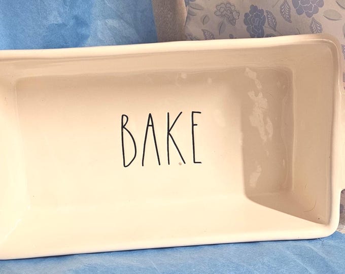 A Rae Dunn Artisan Collection loaf pan features the word "BAKE" inscribed on the inside. (RD)6