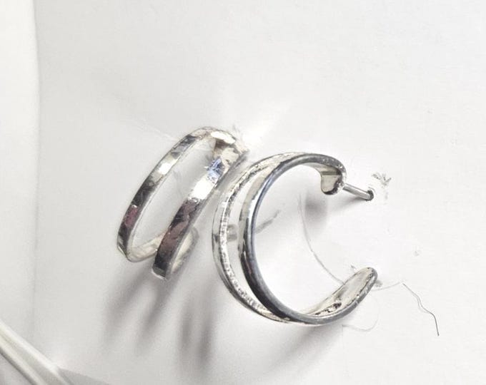 Presenting silver-colored double hoop earrings featuring a striking hammered texture. (Box)