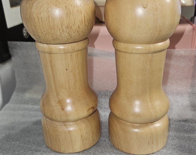A vintage set of wooden salt and pepper shakers featuring a grinder for the pepper.grinding pepper shaker B4/21