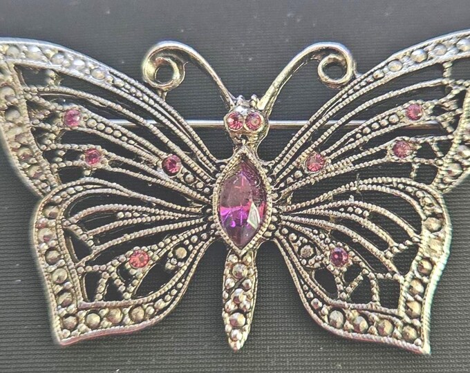 Vintage Retired Sophia Butterfly Pin with purple and white stones on a black metal frame.(closet)