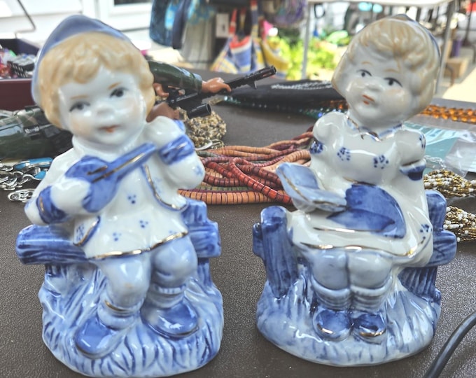 Musical figurines that are very vintage are a little boy playing a guitar and a young lady singing from a hymnal. C7/15