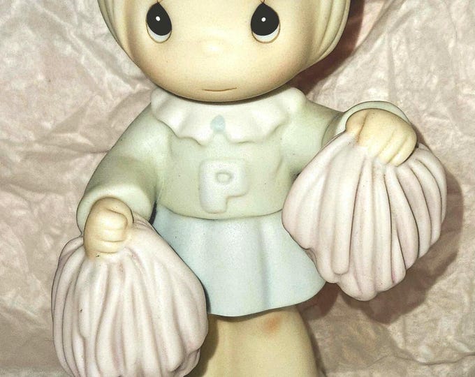 The retired Precious Moments figurine is titled “Cheers to the Leader.”  Figurine Box 2/12