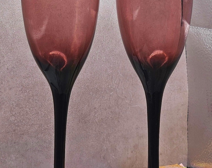 Set of 2 rare champagne flutes in a lovely amethyst color and shape. Each flute is 9 inches tall and holds 6 ounces of liquid. D3/19