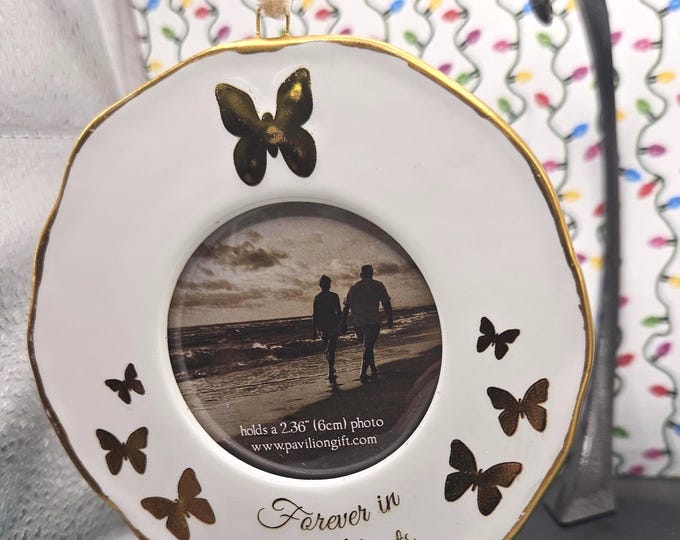 This vintage 4-inch photo frame features a butterfly theme and gold trim. It also has the message "Forever in our hearts". B2/4