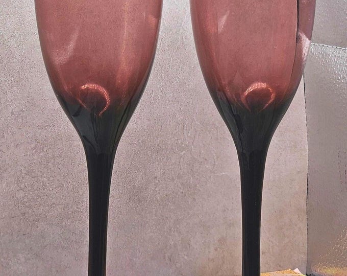 Set of 2 rare champagne flutes in a lovely amethyst color and shape. Each flute is 9 inches tall and holds 6 ounces of liquid. D3/19