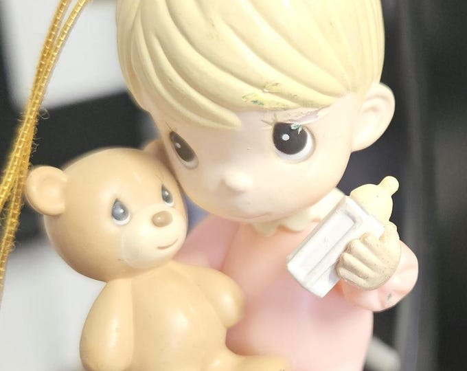 Precious Moments plastic ornament depicting a baby girl feeding a bottle to a teddy bear.A6/13