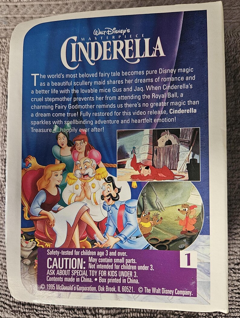 May include: A VHS tape featuring the Disney classic Cinderella. The cover features a colorful illustration of Cinderella, Prince Charming, and the mice Gus and Jaq. The text on the cover reads "Walt Disney's Masterpiece Cinderella". The back of the tape includes a safety warning and copyright information.