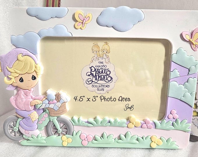 Precious Moments 2002 figurine of a girl riding a bike, item number 118520. (Jew)