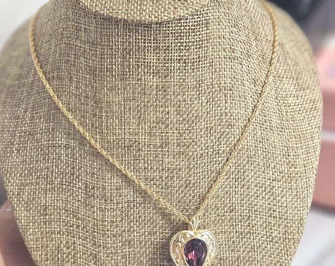 Vintage 1980s Avon Simply Heart pendant necklace featuring a gold-tone chain and an amethyst-colored stone.