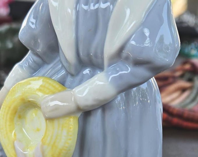 Porcelain Young lady in a blue dress carrying a yellow hat C7/6
