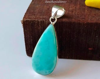 May include: A teardrop-shaped pendant with a vibrant turquoise stone set in a silver bezel. The pendant has a polished finish and a loop for a chain. The text "banithanissilver07" is visible on the top.