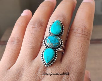 May include: A silver ring featuring three turquoise stones. The stones are teardrop and oval shaped, set in a beaded bezel. The ring is on a hand. The text "SilverJewellery2025" is at the bottom.
