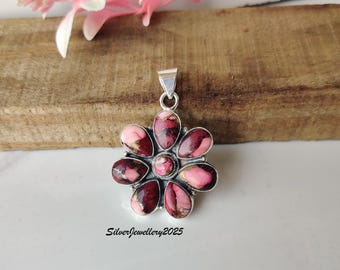 May include: A silver pendant in a flower shape. The pendant has a central pink stone, surrounded by pink and burgundy petals. The text "SilverJewellery2025" is visible at the bottom.