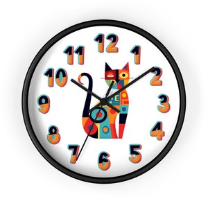 May include: A black framed clock with white face and black hands. The clock features a colorful geometric cat design in the center. The numbers 1 through 12 are displayed around the clock face.