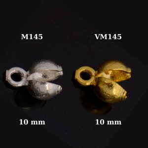 May include: Two metal end caps for jewellery making, one silver and one gold. Each cap is 10 mm in size and has a small loop at the top for attaching to a chain or cord. The caps are labelled M145 and VM145.