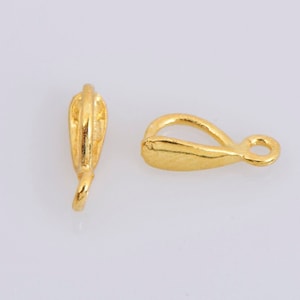 Puede incluir: Dos cierres de metal dorado para la elaboración de joyas. Los cierres están diseñados para sujetar un colgante o un amuleto.