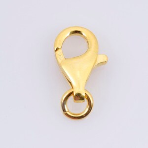 Peut inclure: Fermoir à ressort en métal doré en forme de homard. Le fermoir est conçu pour être attaché à des chaînes ou des colliers de bijoux.