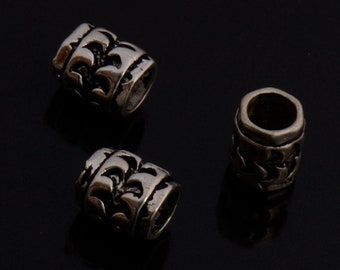 May include: Three silver metal beads with a decorative pattern. The beads are cylindrical and have a smooth, polished finish.