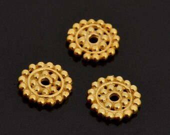 May include: Three gold-colored metal bead caps with a circular design. Each cap has a small hole in the center.