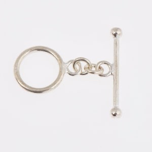 May include: Silver-toned toggle clasp with a round ring and a bar with two rounded ends.