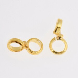 May include: Two gold-toned metal jump rings, one with a single ring and the other with two connected rings.