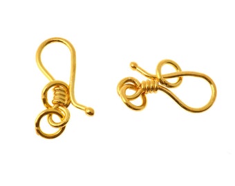 May include: Two gold-toned metal clasps for jewelry making. Each clasp has a loop on one end and a hook on the other end.