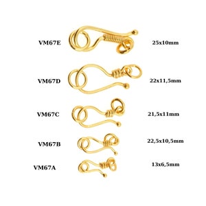 Könnte beinhalten: Fünf goldfarbene Metallverschlüsse in verschiedenen Größen, beschriftet mit VM67A, VM67B, VM67C, VM67D und VM67E. Jeder Verschluss hat einen Haken und eine Schlaufe, und die Maße sind in Millimetern neben jedem Verschluss angegeben.
