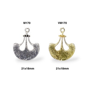 May include: Two metal pendant charms, one silver-toned and one gold-toned, each with a unique fan-shaped design. The charms are 21x18mm in size and feature a textured surface. The text "M170" and "VM170" are above each charm.