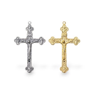 May include: Two ornate crucifixes, one silver and one gold, with a detailed depiction of Jesus Christ on the cross.