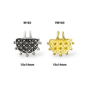 May include: Two metal clasps, one silver and one gold, with a decorative design. Both clasps are 15x14mm in size. The silver clasp is labeled M183 and the gold clasp is labeled VM183.