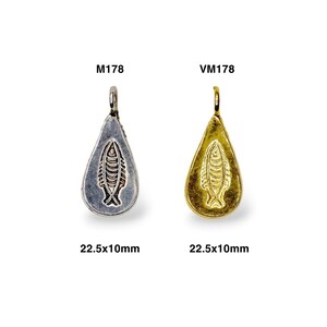May include: Two silver and gold pendants shaped like teardrops with a fish design. The pendants are 22.5 x 10 mm. The silver pendant is labeled M1178 and the gold pendant is labeled VM1178.