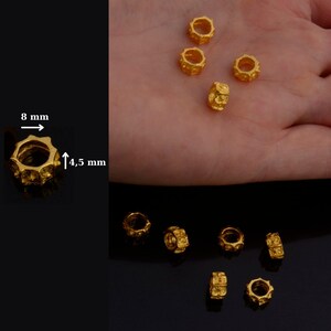 Peut inclure: Huit perles en m&eacute;tal de couleur dor&eacute;e avec une surface textur&eacute;e. Chaque perle mesure 8 mm de diam&egrave;tre et 4,5 mm de hauteur.