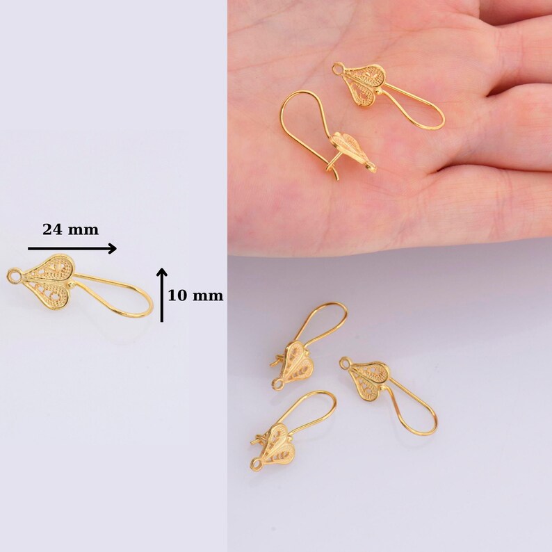 May include: Gold-tone filigree earring hooks, measuring 24 mm long and 10 mm wide. The hooks are shaped like a heart with a delicate, intricate design.
