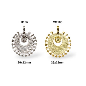 May include: Two silver and gold pendants with a clear stone in the center. The pendants are round and have a textured surface. The pendants are 26x22mm in size. The silver pendant is labeled M185 and the gold pendant is labeled VM185.