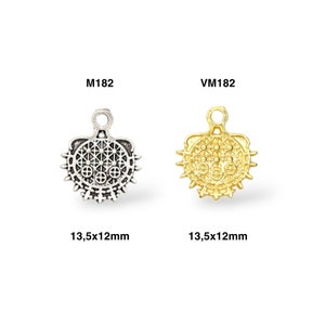 May include: Two silver and gold charm pendants with a detailed geometric design. The pendants are 13.5 mm by 12 mm and have a loop at the top for attaching to a chain or bracelet. The charms are labeled M182 and VM182.